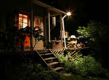 Home security lighting - Dark home with single outside light shining on wooden steps