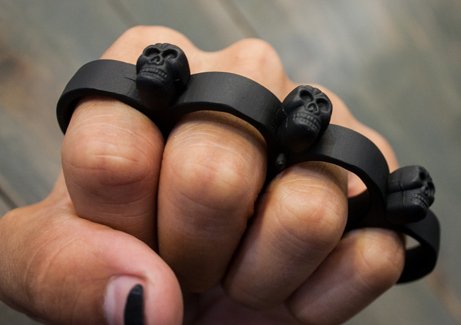 Metal knuckles with small skulls on someones fist