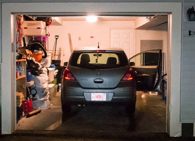 Picture of car parked in a home garage at night