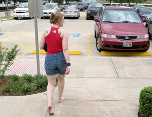 Lady with red top walking to her car in a parking lot