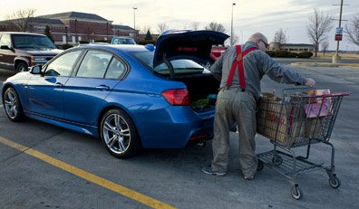 Vehicle Crime - Old man loading groceries into boot of blue car