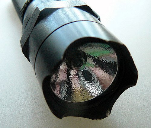 A close up view of the bezel of a tactical flashlight