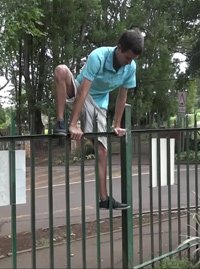 Fence test 2 - Evan climbing over a green steel palisade fence