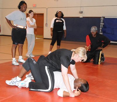 Woman straddling her opponent on the training mat